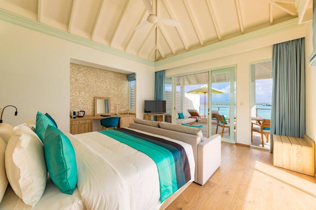 a bedroom with a bed with a view of the ocean at Siyam World Maldives - 24-Hour Premium All-inclusive with Free Transfer in Dhigurah