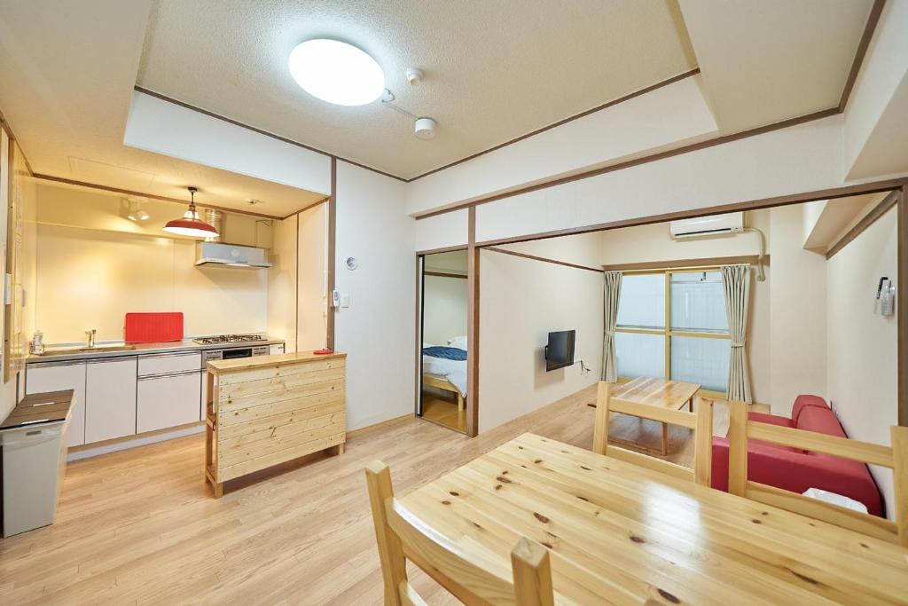 a kitchen and dining room with a wooden table in a room at Canello Hotel in Sendai