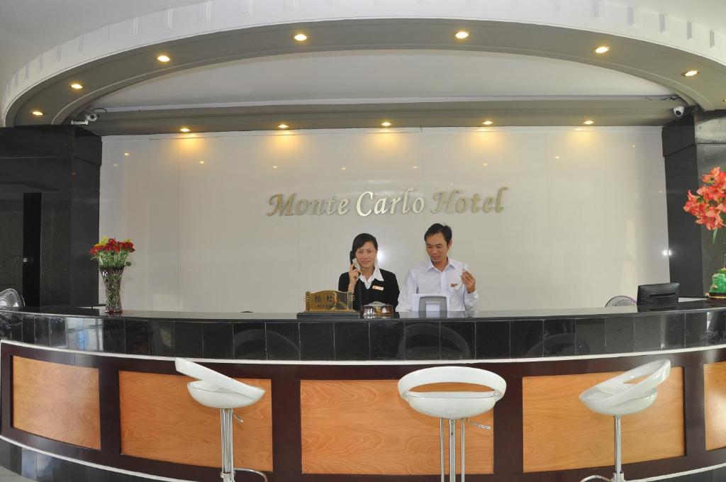 two people standing at a bar in a hotel at Monte Carlo Hotel Hai Phong in Hai Phong