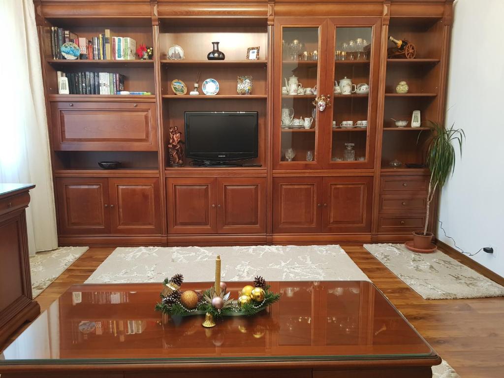 a living room with a wooden entertainment center and a television at Garsoniera Mihaela in Petroşani