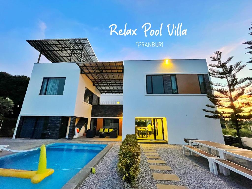 a house with a swimming pool in front of it at Relax Pool Villa Pranburi in Pran Buri