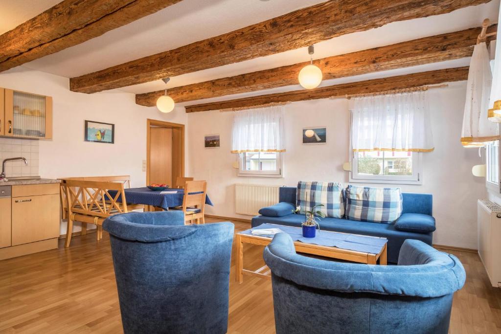 a living room with blue couches and a kitchen at Ferienwohnung Nr 3 in Deggenhausertal