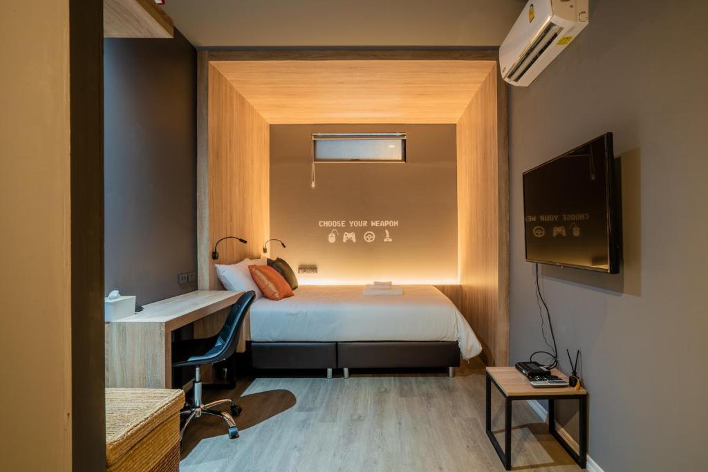 a hotel room with a bed and a tv at TK Bed in Hat Yai