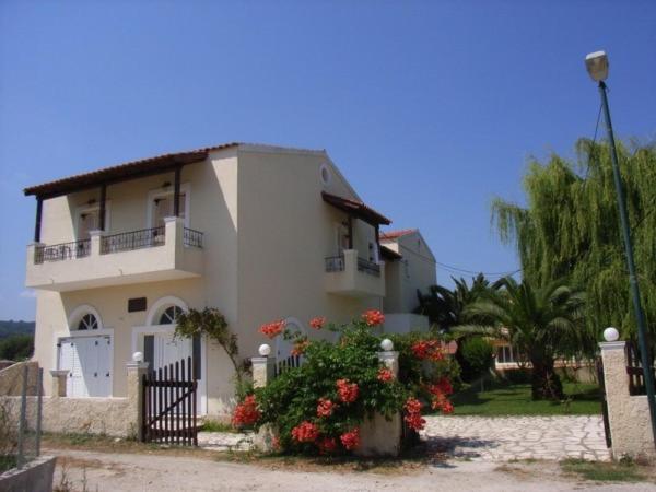 una casa bianca con un cancello e dei fiori davanti di Villa Stefania ad Acharavi