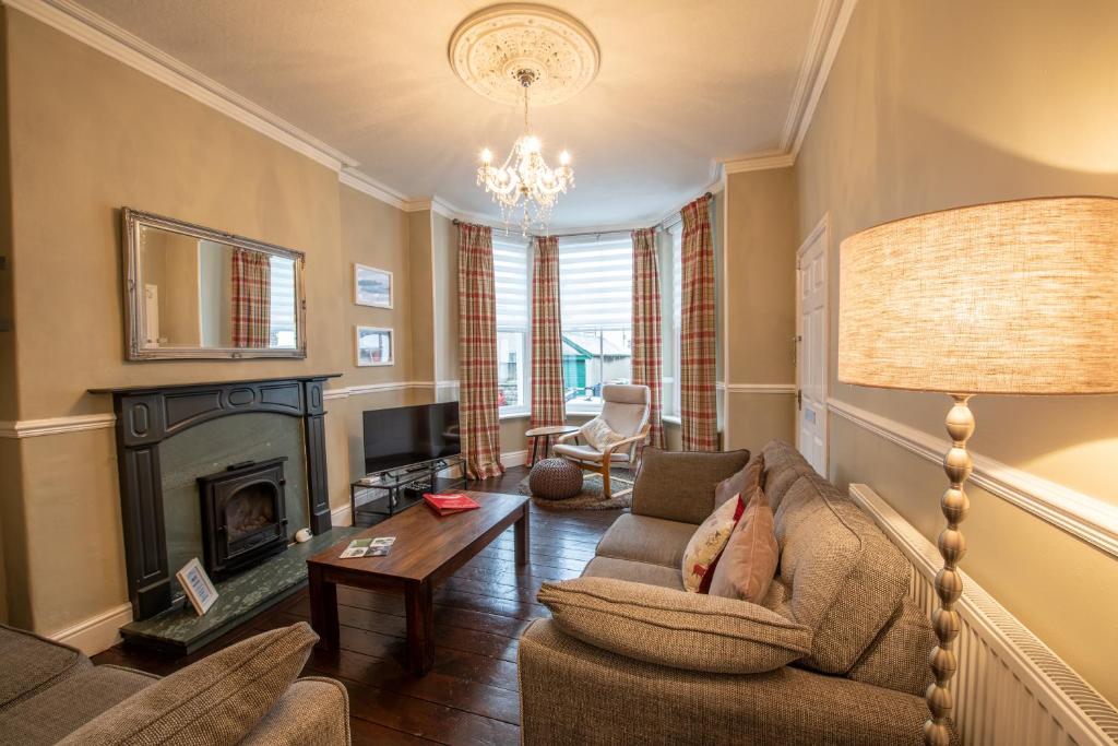 uma sala de estar com um sofá e uma lareira em 25 Church Street em Keswick