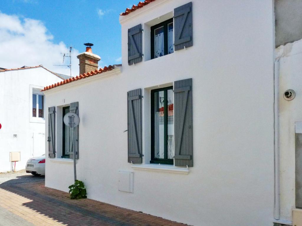 a white house with black windows on a street at Maison de 2 chambres a Saint Gilles Croix de Vie a 300 m de la plage avec terrasse amenagee et wifi in Saint-Gilles-Croix-de-Vie
