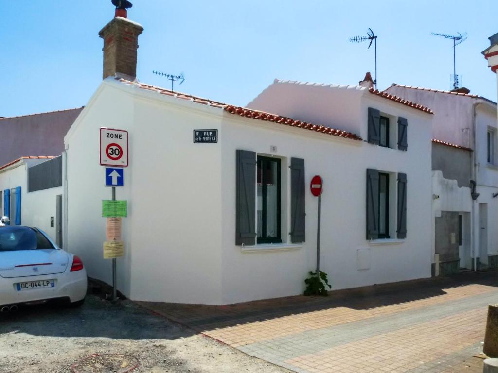 a white building with a car parked in front of it at Maison de 2 chambres a Saint Gilles Croix de Vie a 300 m de la plage avec terrasse amenagee et wifi in Saint-Gilles-Croix-de-Vie