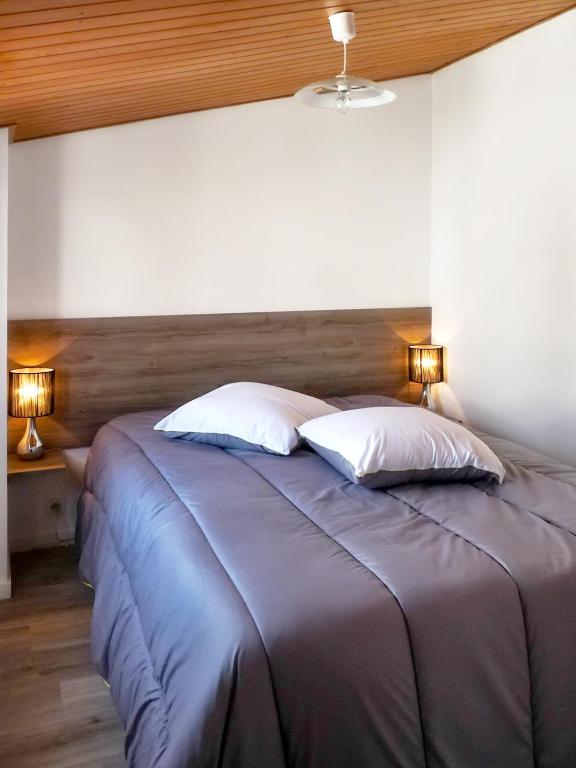 a bedroom with a large bed with two pillows at Maison de 2 chambres a Saint Gilles Croix de Vie a 300 m de la plage avec terrasse amenagee et wifi in Saint-Gilles-Croix-de-Vie