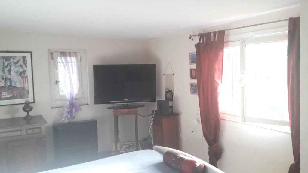 a living room with a flat screen tv on the wall at Maison charmante à Peille + jardin in Peille