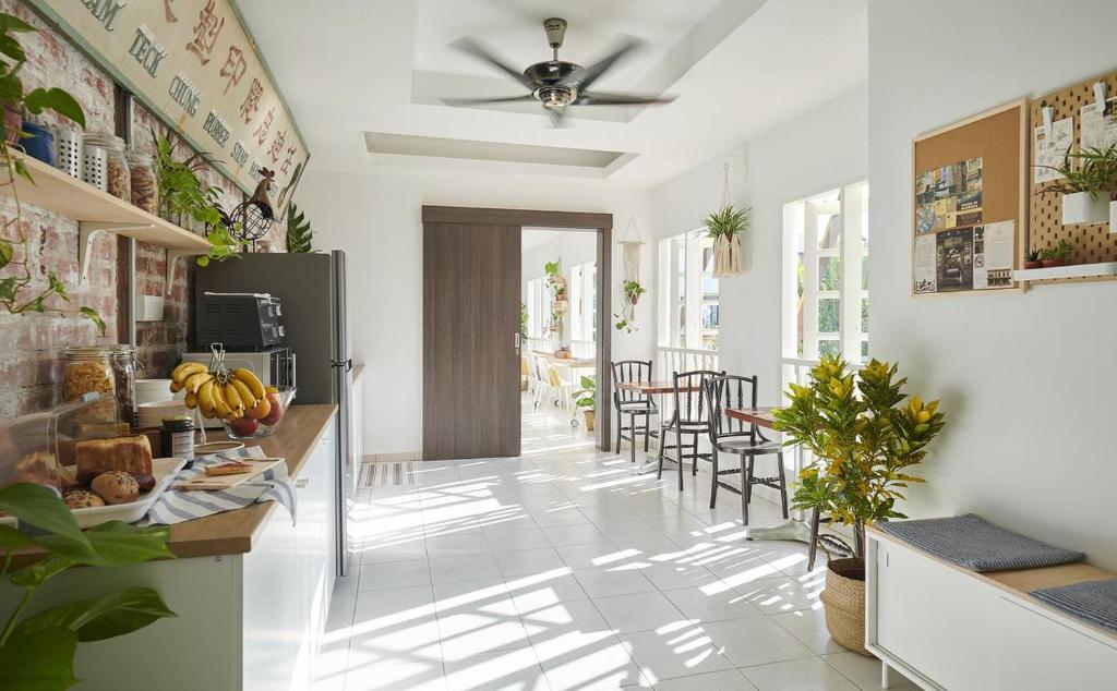 a kitchen with white walls and a ceiling fan at Sleepy Nomad Guesthouse in Melaka