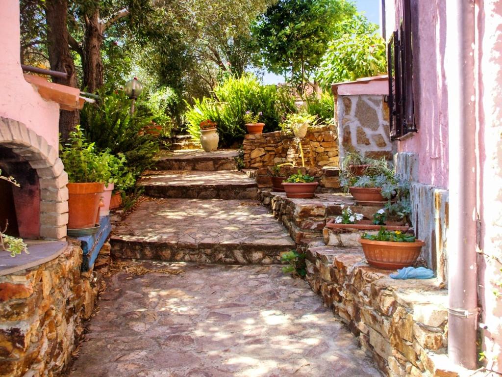 a stone walkway with potted plants on the side of a building at 3 bedrooms apartement with sea view enclosed garden and wifi at Posada 2 km away from the beach in Posada