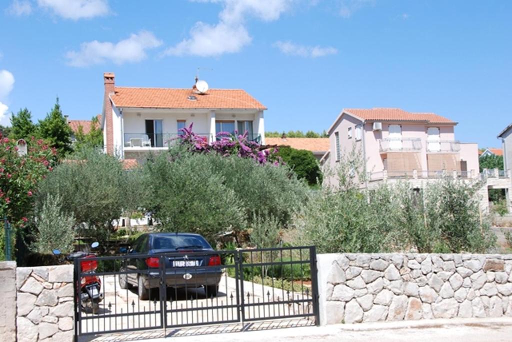 a black car parked in front of a house at Spacious apartment in Stari Grad, 80 m², serene garden in Stari Grad