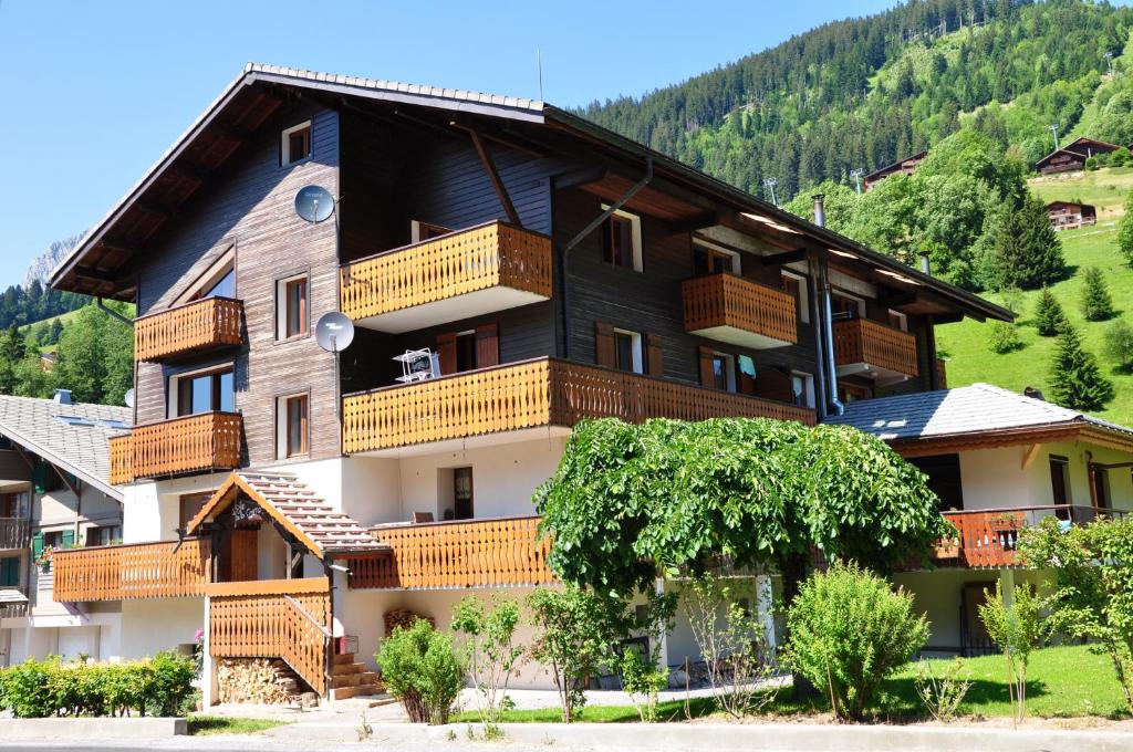 Un gran edificio con balcones a los lados. en Appartement lumineux à La Chapelle-d'Abondance, vue montagne., en La Chapelle-dʼAbondance