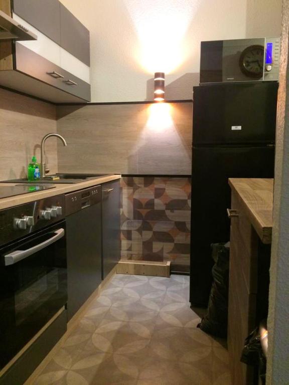 a kitchen with a black refrigerator and a sink at Appartement d&#39;une chambre avec balcon amenage et wifi a Briancon in Briançon