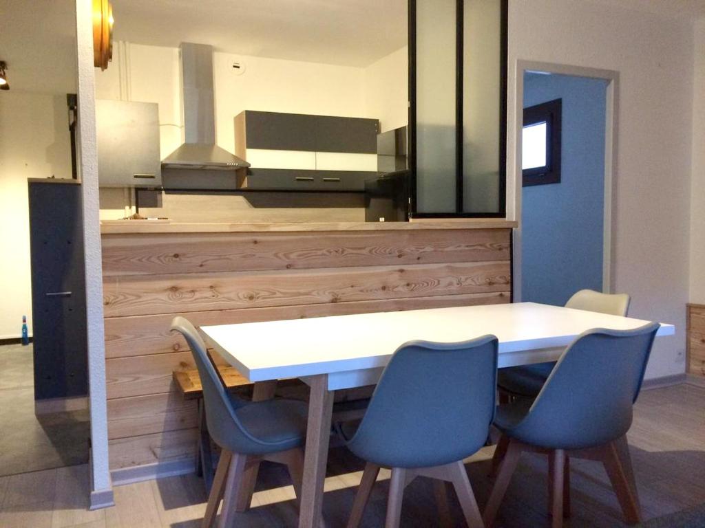 a dining room table with four blue chairs in a room at Appartement d'une chambre avec balcon amenage et wifi a Briancon in Briançon