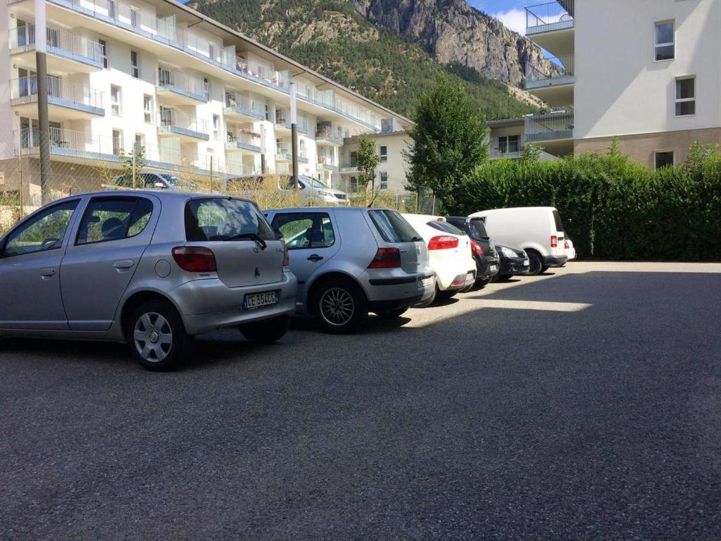 a row of parked cars parked next to a building at Appartement d&#39;une chambre avec balcon amenage et wifi a Briancon in Briançon