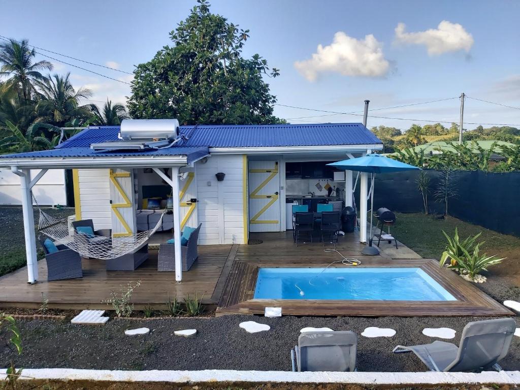 a small house with a swimming pool in the backyard at Bungalow d'une chambre avec piscine privee jardin clos et wifi a Sainte Rose in Sainte-Rose