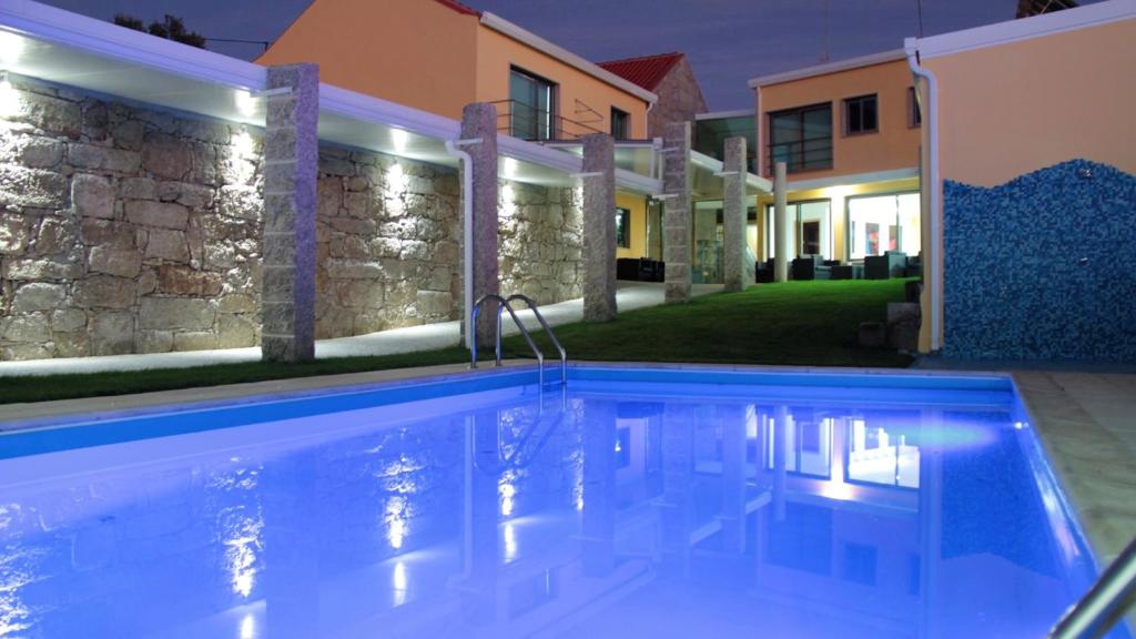 una piscina frente a una casa por la noche en 2 bedrooms bungalow with city view shared pool and jacuzzi at Pinhel, en Pinhel