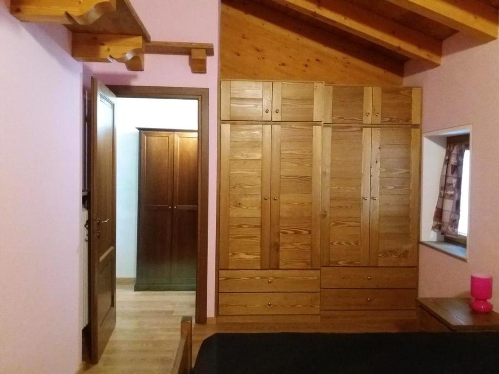 a room with a closet with wooden cabinets at One bedroom appartement with enclosed garden and wifi at Aymavilles 7 km away from the slopes in Aymavilles