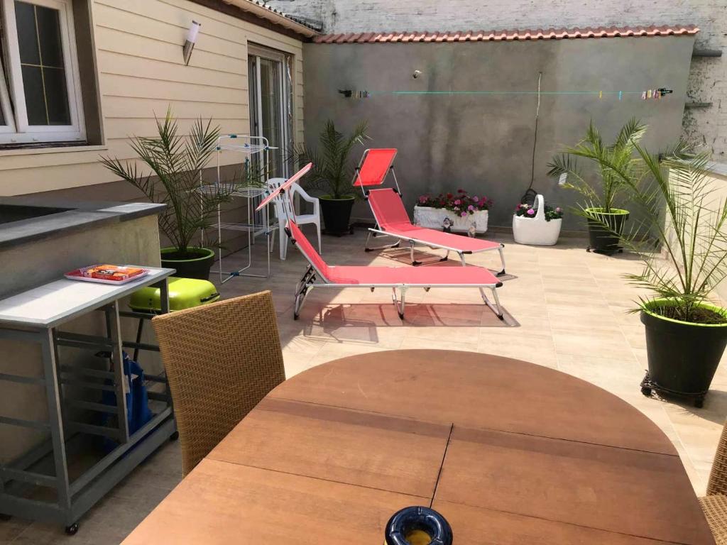 patio z krzesłami i stołem oraz roślinami w obiekcie Maison de 2 chambres avec wifi a Berlaimont w mieście Berlaimont