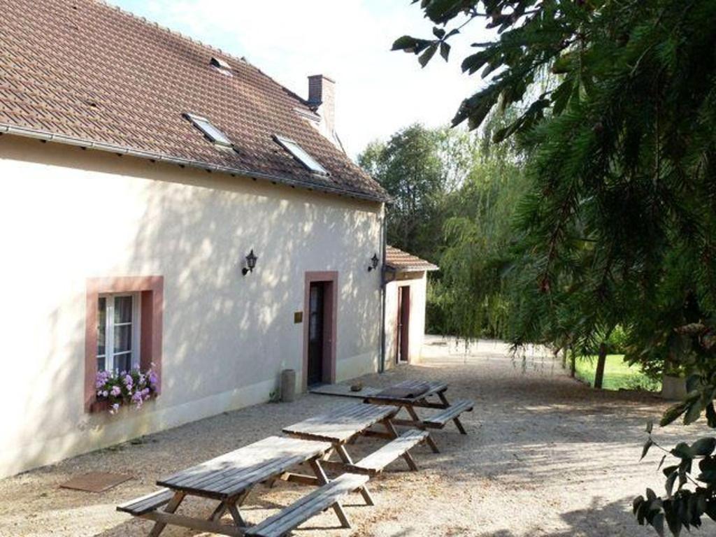 a group of picnic tables outside of a building at Maison spacieuse à Nevoy avec jardin de 200 m², idéal pour groupes ! in Nevoy