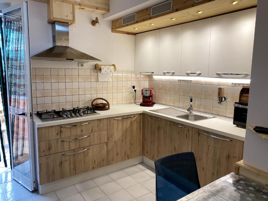 uma cozinha com armários de madeira e um forno com placa de fogão em One bedroom apartement with sea view enclosed garden and wifi at Realmonte 2 km away from the beach em Realmonte