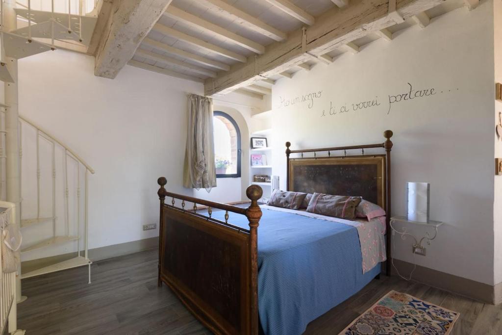 um quarto com uma cama com um edredão azul em One bedroom house with shared pool enclosed garden and wifi at Trequanda em Trequanda