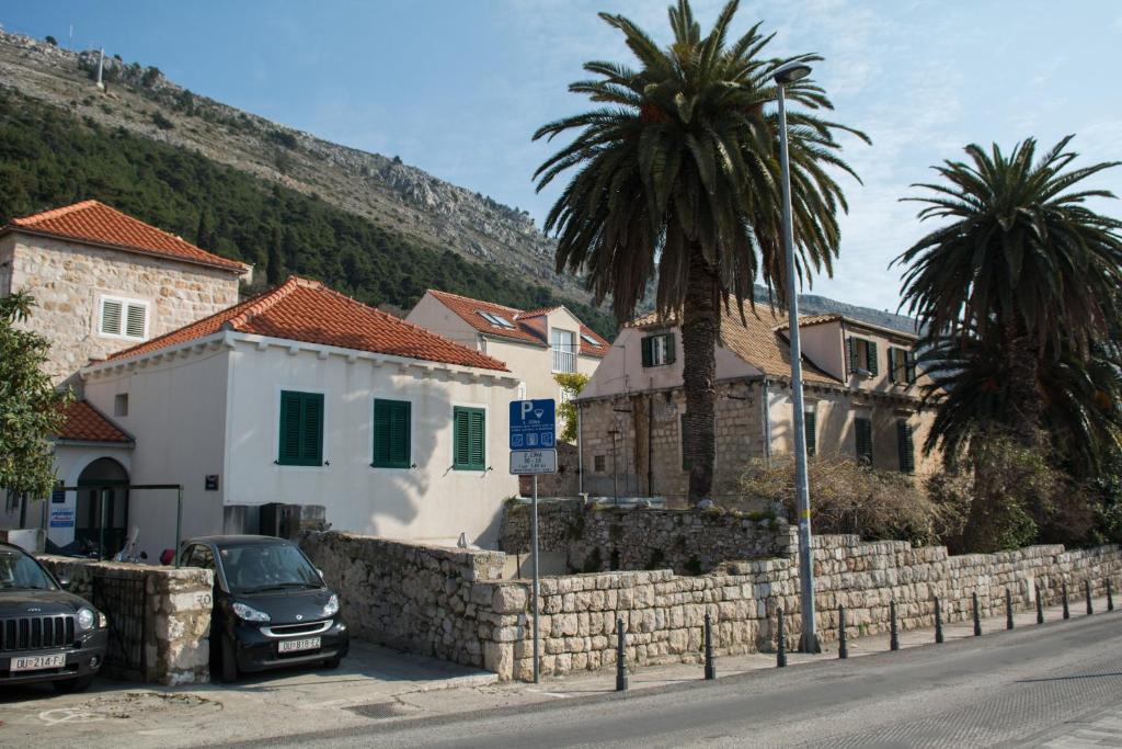 un grupo de casas y palmeras en una calle en Apartment Monika, en Dubrovnik