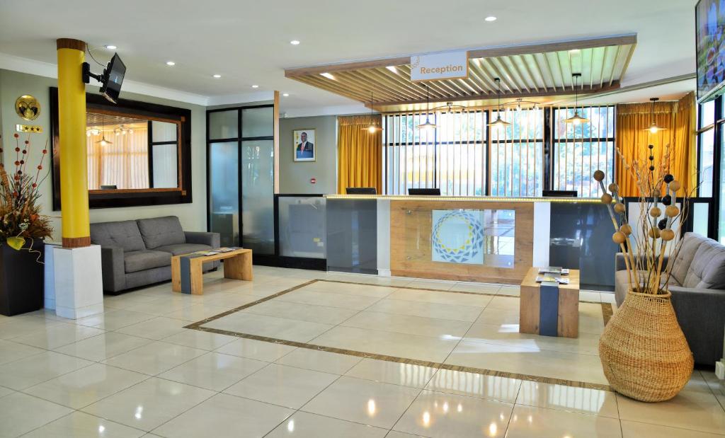 a lobby with couches and a fireplace in a building at Cresta Oasis Hotel in Harare