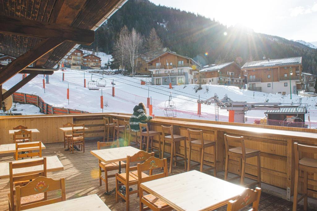 a restaurant with tables and chairs and a ski slope at BodyGo Hostel in Valfréjus