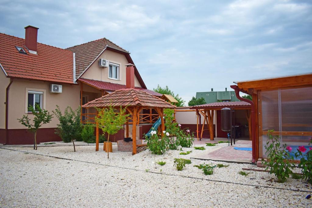 een huis met een achtertuin met een tuinhuisje bij Tündérfátyol apartmanház in Poroszló