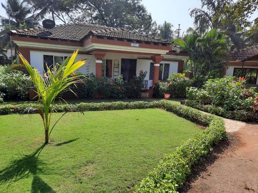 une maison avec une pelouse devant elle dans l'établissement Vila Romila, à Cavelossim