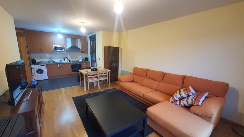 ein Wohnzimmer mit einem Sofa und einer Küche in der Unterkunft Las Nieves de Lillo in Puebla de Lillo