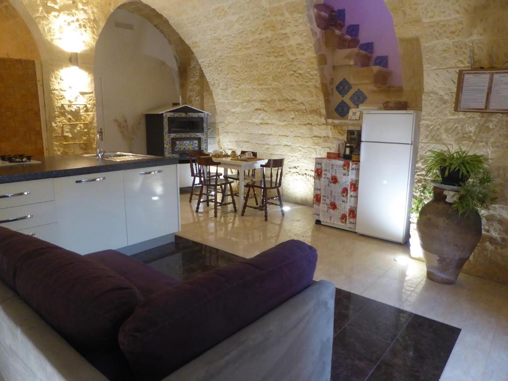 cocina y sala de estar con sofá y mesa en Dammuso dell'Arco, en Palazzolo Acreide
