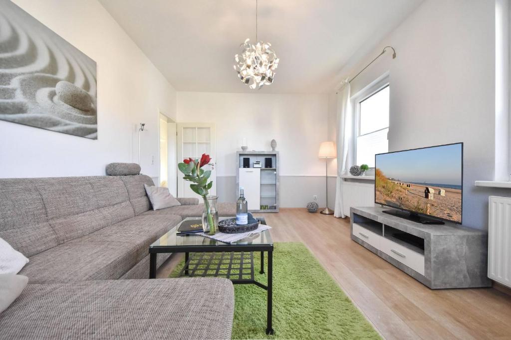 ein Wohnzimmer mit einem Sofa und einem Flachbild-TV in der Unterkunft Haus Thalia 3 - Seestern in Ahlbeck