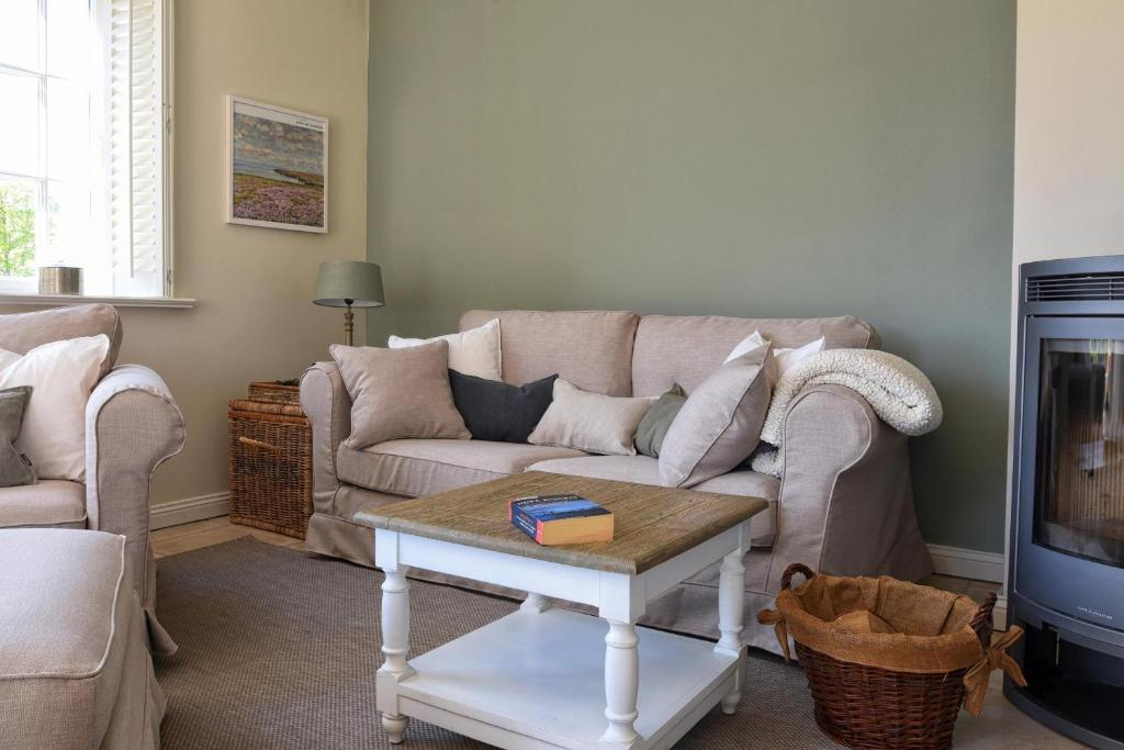 a living room with a couch and a coffee table at Jettes Hus in Midlum