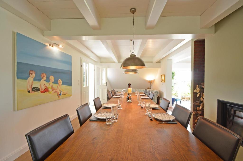 a large long table in a room with chairs at Reethus Doerpsend Haus 1 in Midlum
