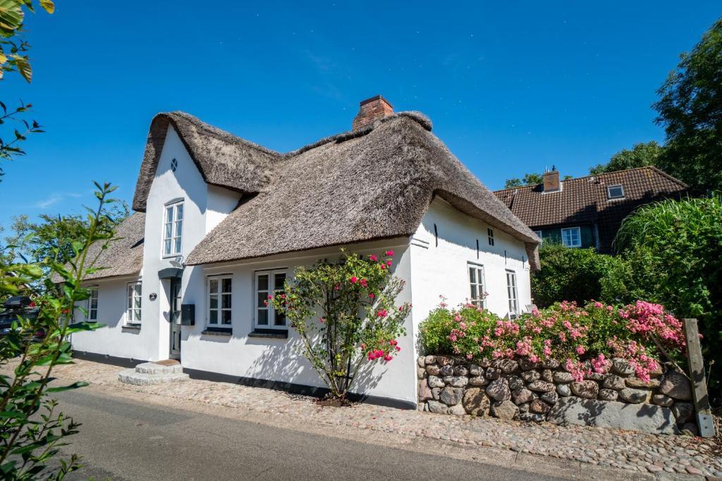 a white cottage with a thatched roof at Kleine Flucht in Oevenum