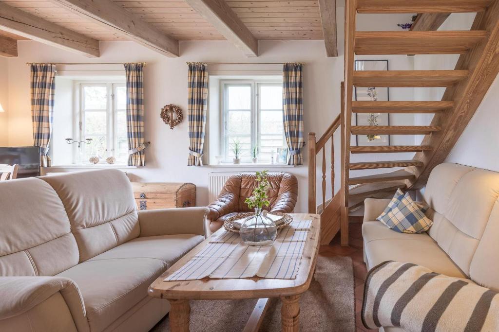 a living room with a couch and a table at Ferienhaus Geest auf Föhr in Borgsum