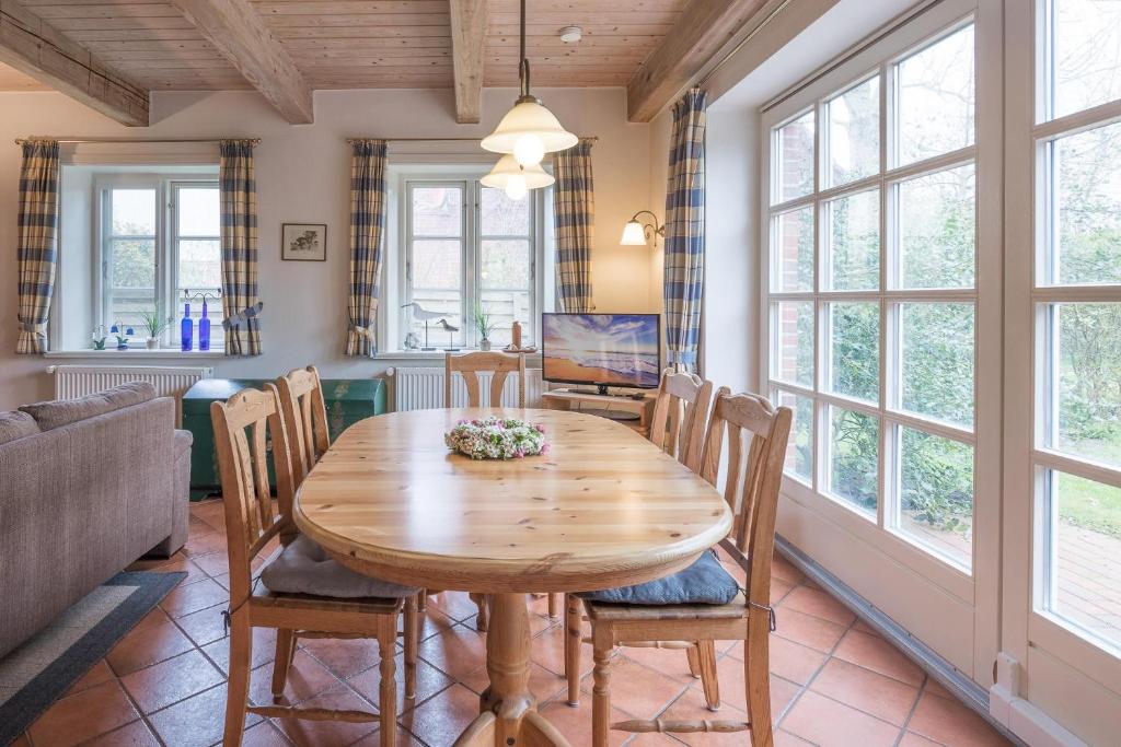 uma sala de jantar com uma mesa de madeira e cadeiras em Ferienhaus Marsch auf Föhr em Borgsum