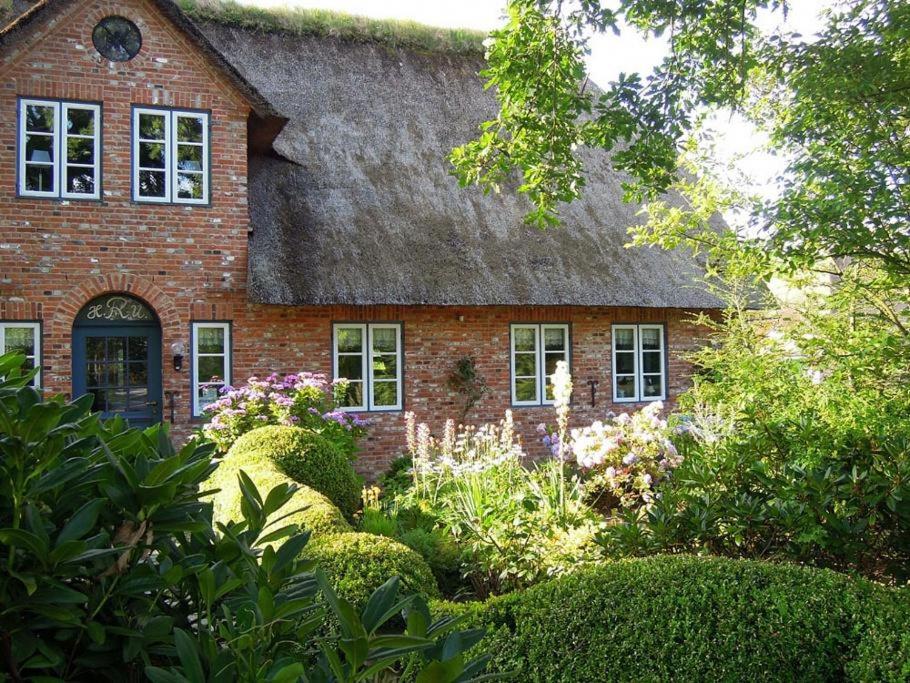 een oud stenen huis met een grasdak bij Reethus Schobüll in Husum