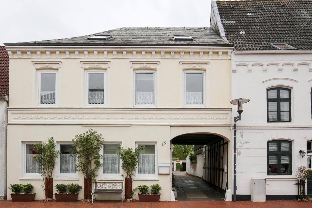 a large white building with an archway at Apartmenthaus Tönning Sanddüne in Tönning