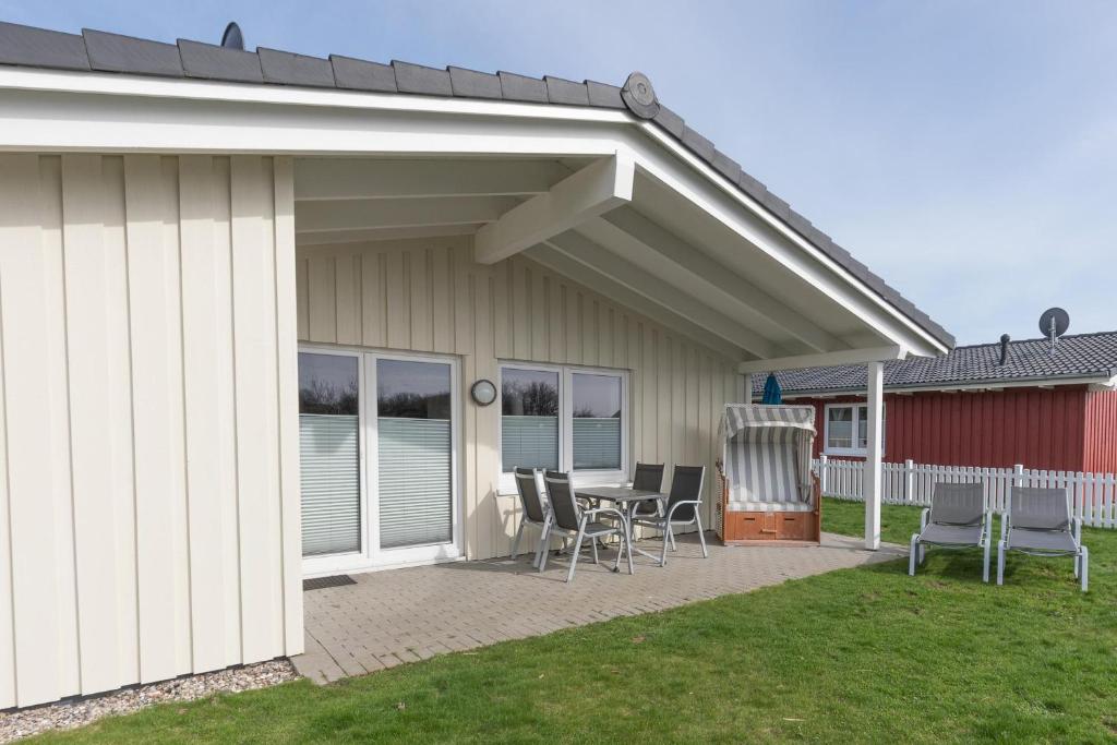 eine Terrasse mit Stühlen und einem Tisch vor einem Haus in der Unterkunft Ferienhaus Steinwälzer in Dagebüll