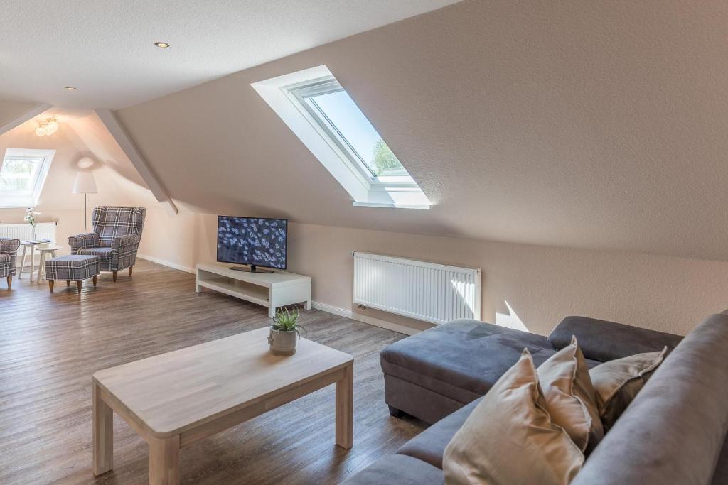 a living room with a couch and a skylight at Schobüller Seestern in Husum