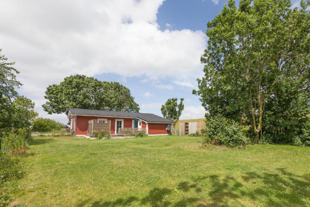 een huis met een rood huis in een tuin bij Altes Schäferhaus in Nordstrand