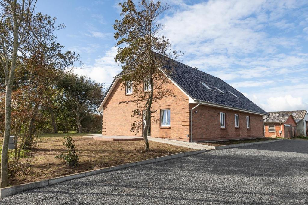 une maison en briques avec un toit solaire dans une rue dans l'établissement Achtern Diek, à Dagebüll