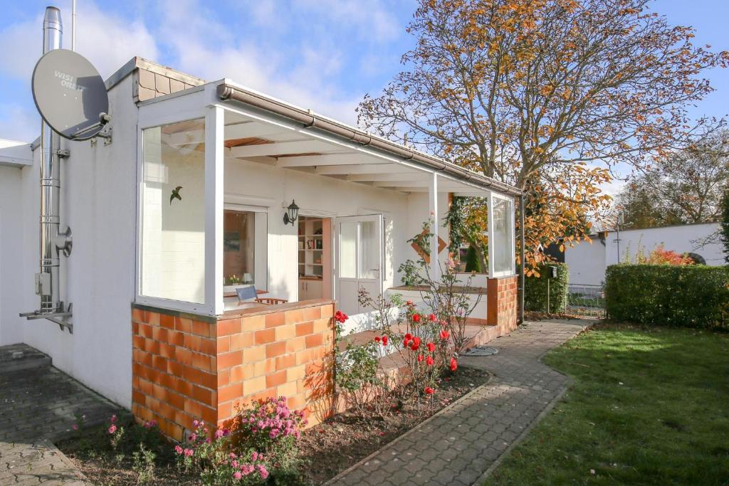 a white house with a window and a brick wall at Ferienhaus Bobby in Stahlbrode