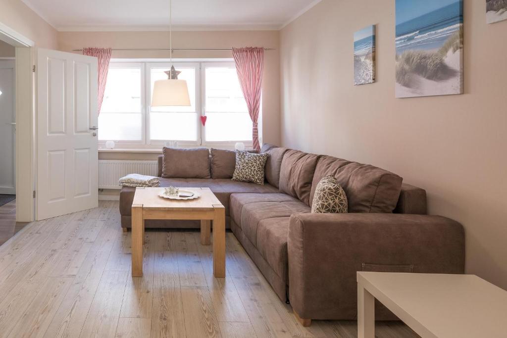 ein Wohnzimmer mit einem braunen Sofa und einem Tisch in der Unterkunft Tine in Husum