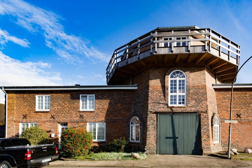 a brick building with a balcony on top of it at Lodge an der Muehle in Bredstedt