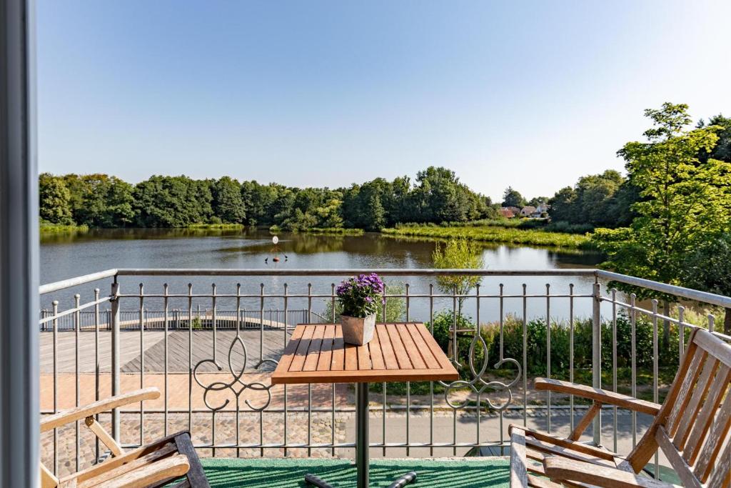 una mesa en un balcón con vistas al lago en Alte Wassermuehle Am Bach, en Bredstedt
